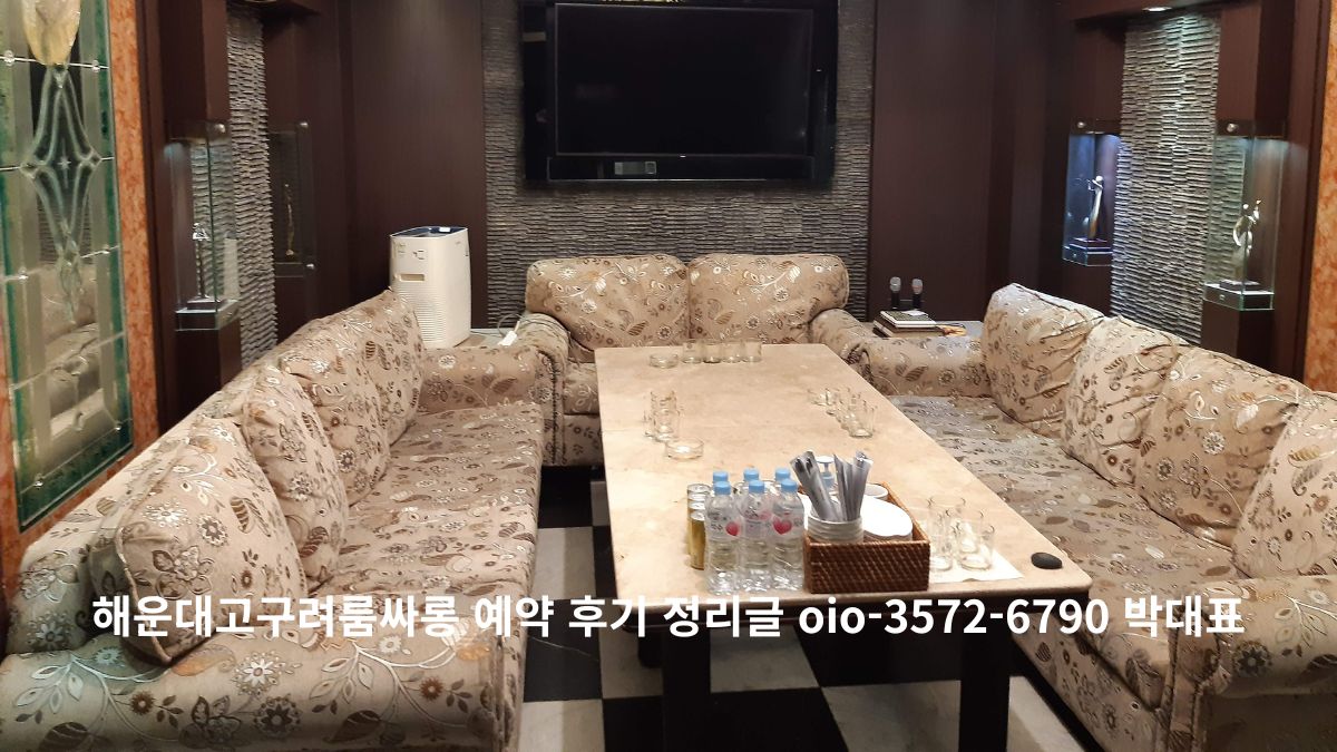 대형 테이블과 패턴 소파가 배치된 해운대 프라이빗 라운지 룸 내부, TV와 공기청정기가 있는 고급 인테리어 공간